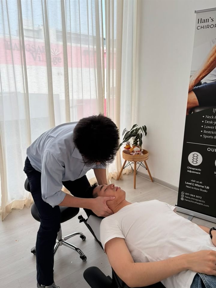 Siew Wai Han assessing a patient’s neck while they lie face-up
